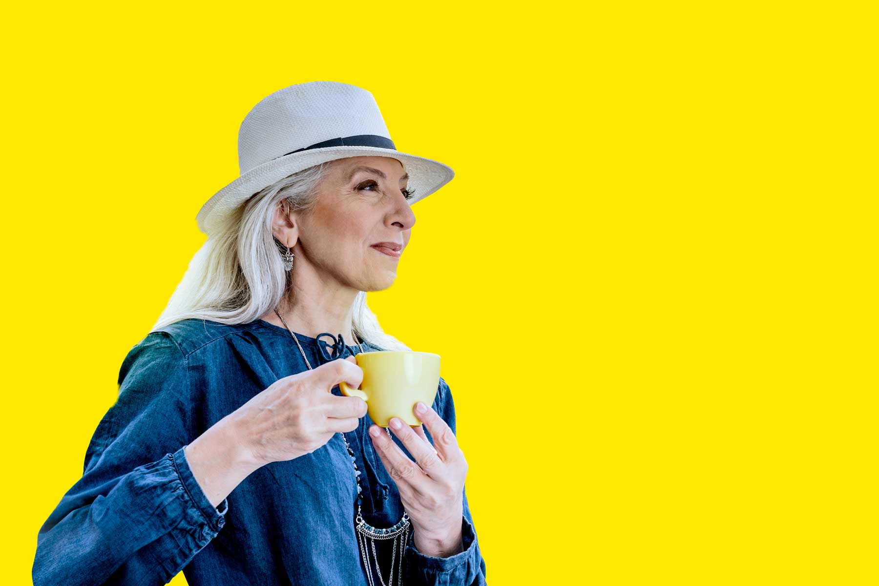 Senior woman enjoying a cup of coffee, showcasing a relaxed lifestyle and vibrant background.
